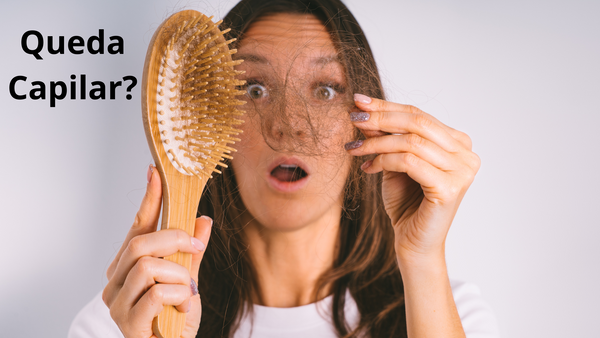 Mulher com uma escova de cabelo, mostrando cabelo com queda capilar